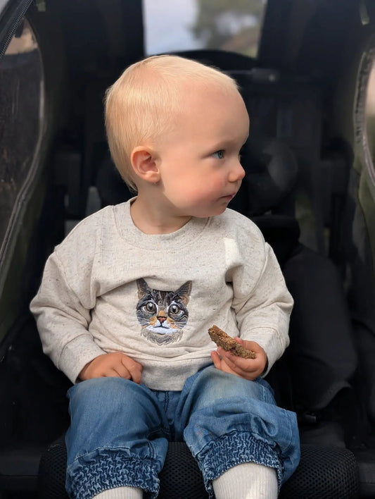 Barn med portrett av egen katt på genser