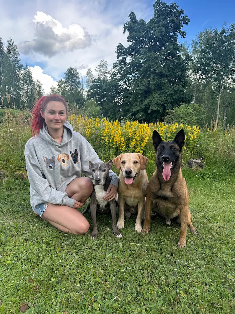 Hundeeier iført hettegenser med personlig broderi av tre hunder