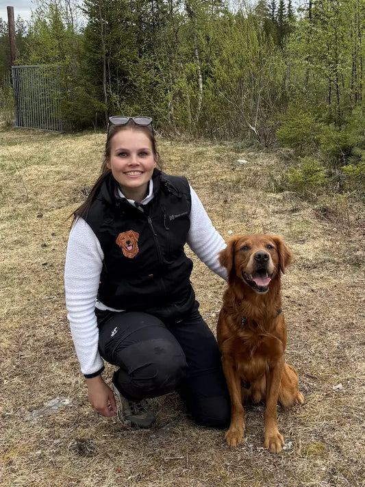 Hundeeier iført hundetrenervest med personlig broderi av hund